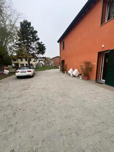 伊莫拉LA CASA DI GIADA uscita autostrada di Imola e a 5 minuti dal centro di Imola - parcheggio privato incluso的停在大楼旁的车道上的汽车
