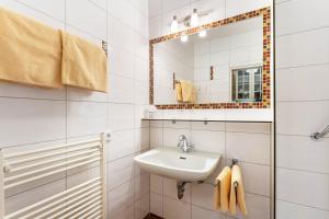 une salle de bain blanche avec un lavabo et un miroir dans l'établissement Strandhof Möhnesee, à Wamel 52 autres photos