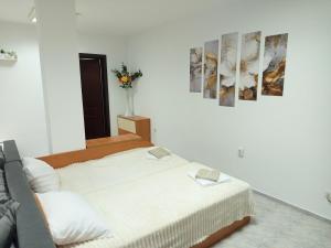 a bedroom with two beds and a vase of flowers at Alena'Studio in Gabrovo