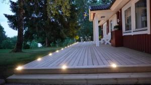 a wooden deck with lights on the side of a house at Landhaus Måsberget in Kristinehamn
