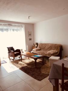 un soggiorno con un divano e un tavolino da caffè di Le 5 ter - Cozy, quiet accommodation a Baud