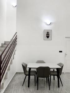 La Villa Moris, meublée et bien située في ليبرفيل: غرفة طعام مع طاولة وكراسي وسلالم