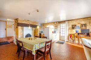 eine Küche und ein Esszimmer mit Tisch und Stühlen in der Unterkunft Le Hibou - La Cipière Gîtes in Bardenac