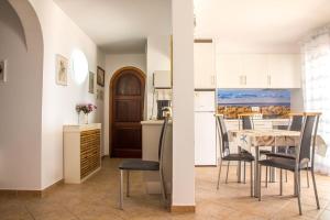 una cucina e una sala da pranzo con tavolo e sedie di Gerry&Lotti Apartment a Son Bou