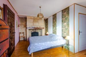 ein Schlafzimmer mit einem Bett und einem Kamin in der Unterkunft Le Hibou - La Cipière Gîtes in Bardenac + 13 Fotos
