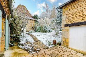 ein schneebedeckter Hof mit einer weißen Garage in der Unterkunft Le Hibou - La Cipière Gîtes in Bardenac