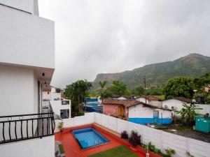 uma vista a partir da varanda de um edifício com piscina em Ventara Bliss Bungalow by Palette | Pvt Pool | Lonavala em Kārli