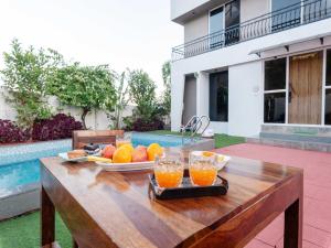 uma mesa de madeira com uma bandeja de frutas sobre ela em Ventara Bliss Bungalow by Palette | Pvt Pool | Lonavala em Kārli