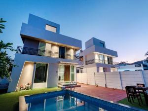 uma casa com uma piscina na frente em Ventara Bliss Bungalow by Palette | Pvt Pool | Lonavala em Kārli