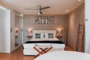 a bedroom with a bed and a ceiling fan at The Infinity 180 Luxury Suites in Milia +89 photos