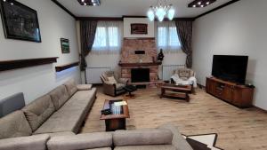 a living room with a couch and a television at Vila na Rtnju in Rtanj