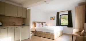 a bedroom with a bed and a sink and a window at Ferienwohnung Mimosa 302 in Wiggensbach