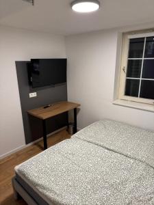 Un dormitorio con dos camas y una mesa y un televisor. en Große Wohneinheit Im Hotel weisses Lamm, en Bruchsal