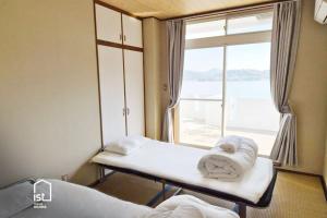 Una habitación de hospital con dos camas y una ventana. en ist villa 06 Private Beachfront Sleeps 16, en Wada