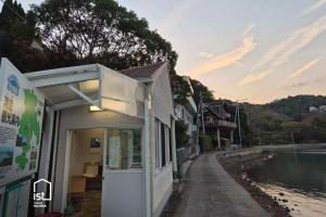 a building next to a body of water at Large Beachfront Island Villa Sleeps 12 Ideal for Groups in Bizen