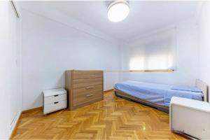 a bedroom with a bed and a wooden floor at Apartamento en 1ª línea de playa con parking privado in El Campello