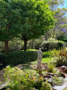 a statue sitting in the middle of a garden at Wollongong Tiny Home in Coniston +4 photos