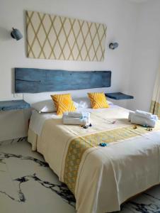 托尔托利Turchese House Bed and Breakfast的一间带两张床和大床头的卧室