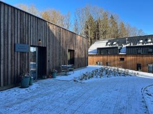 a building with snow on the ground in front of it at Apartmány Hraničná s privátním wellness in Bedřichov