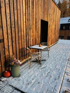 a patio with a table and a bench and a fence at Apartmány Hraničná s privátním wellness in Bedřichov