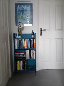 ein Bücherregal voller Bücher neben einer Tür in der Unterkunft Homely in Matson