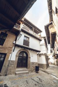 Un edificio blanco con una puerta y un balcón. en Casa Rural "Calle Real" en La Vera, en Villanueva de la Vera