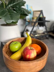 a wooden bowl filled with apples oranges and bananas at Wollongong Tiny Home in Coniston