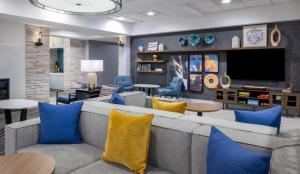 佳侬斯堡匹兹堡索思波恩特希尔顿惠庭套房酒店的客厅配有灰色的沙发和蓝色的枕头。