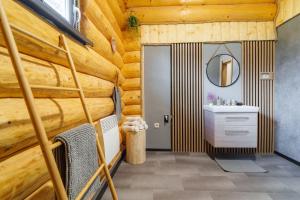 une salle de bain dans une cabane en rondins avec un lavabo et un miroir dans l'établissement Zrub Polomka, à Brezno 46 autres photos