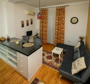 a kitchen and living room with a couch and a table at Apartman Lusi Vranje in Vranje