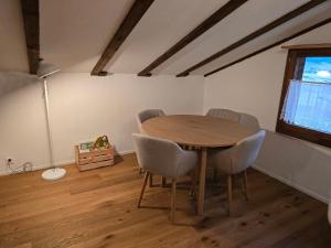 a dining room with a wooden table and chairs at Charming Louisa Zimmer Roof - KEINE KÜCHE in Rueras