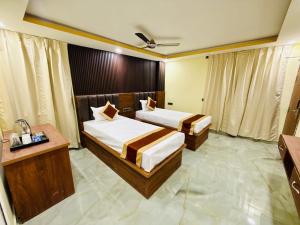 una habitación de hotel con dos camas y un escritorio en Hotel Diamond Crest, Patna, en Lok Nayak Jayaprakash Airport