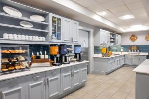 佳侬斯堡匹兹堡索思波恩特希尔顿惠庭套房酒店的一间大厨房,配有白色的橱柜和一个带食物的柜台