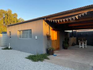ein kleines Haus mit Terrasse und Tisch in der Unterkunft Rolbos Accommodation in Beaufort West