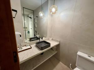 ein Badezimmer mit Waschbecken und Spiegel in der Unterkunft Vila Chalés in Mucuri + 18 Fotos