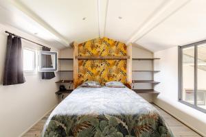 a bedroom with a bed with a yellow headboard at L'Atelier du Clos avec Jacuzzi in Puilboreau