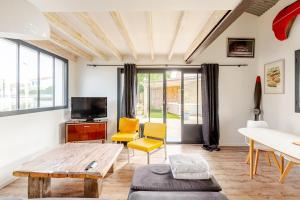 a living room with a table and yellow chairs at L'Atelier du Clos avec Jacuzzi in Puilboreau