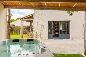 a bath tub in the yard of a house at L'Atelier du Clos avec Jacuzzi in Puilboreau