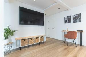 ein Wohnzimmer mit einem großen Flachbildfernseher an der Wand in der Unterkunft Breeze House 2 by Atlantic Holiday in Garajau