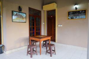 a wooden table and two stools in a room at Shani Villa in Negombo