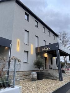 a white building with a sign that reads talinar at Hotel Falken in Hechingen