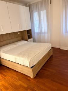 a large bed in a bedroom with a wooden floor at Casa da Luigina 2 in Chioggia