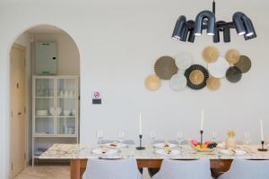 Un comedor con una mesa con sillas y una lámpara de araña. en Lucky Pool Villa Cha-am, en Ban Bo Prakhon