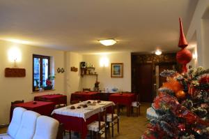 a dining room with a christmas tree and red clothed tables at B&B Dulcamara in Pescasseroli