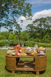 a picnic table with food on it in the grass at amã Stays & Trails - Diffloo Bungalow, Assam in Bokākhāt
