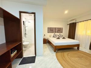 un dormitorio con una cama y un baño en Villa Aniani, en El Nido