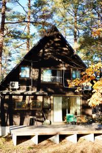 a house with a porch and a patio in front of it at Misorano Chalet in Hakuba