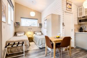 a bedroom with two beds and a table and chairs at Lilla huset Bed & Breakfast - countryside guesthouse, free parking in Örebro