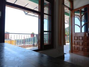 Una habitación con ventana y vista a un balcón. en Dreamcatcher Homestay, en McLeod Ganj