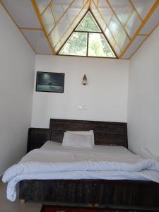 Un dormitorio con una cama grande con ventana. en Dreamcatcher Homestay, en McLeod Ganj